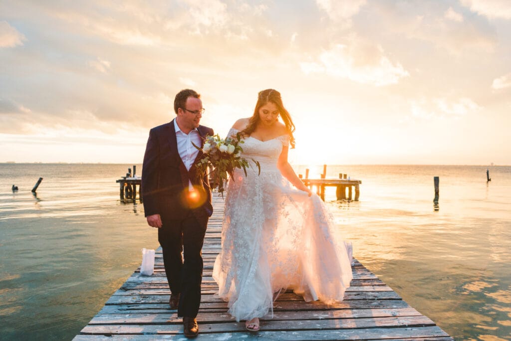 foto de novios caminanado por muelle en ribiera maya