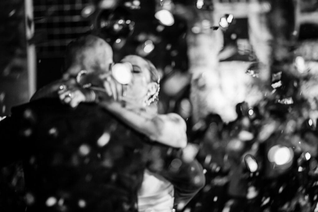 foto blurosa de novios besandose entre lluvia de papelitos