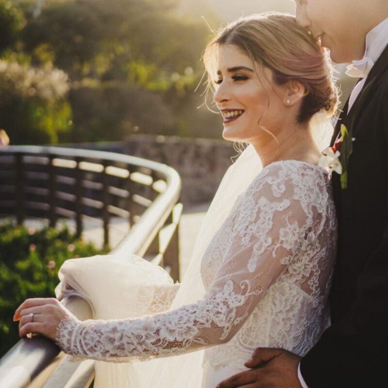 Novia sonriente en una terraza al atardecer, fotografía de boda natural y elegante.